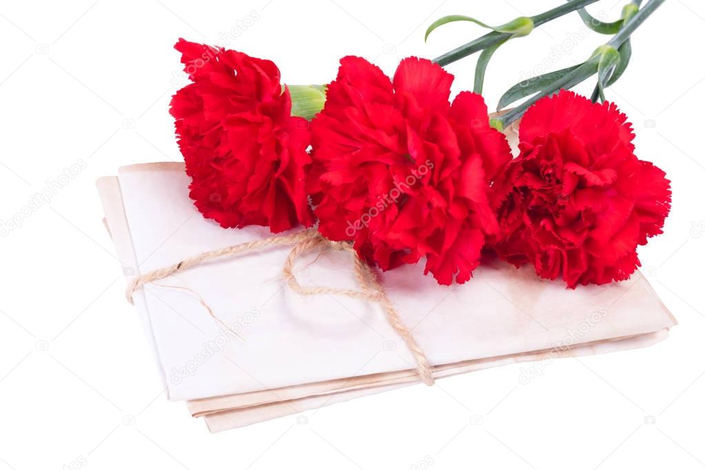 A stack of letters connected by a rope along with red carnations. on a white background