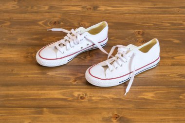 beyaz spor ayakkabı koyu ahşap zemin üzerinde duruyorsun