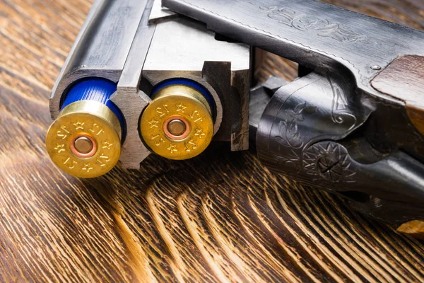 Dos balas en un arma sobre un viejo fondo de madera — Foto de Stock
