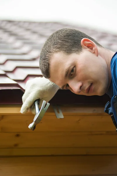 Hombre sosteniendo un martillo en el fondo del techo — Foto de Stock