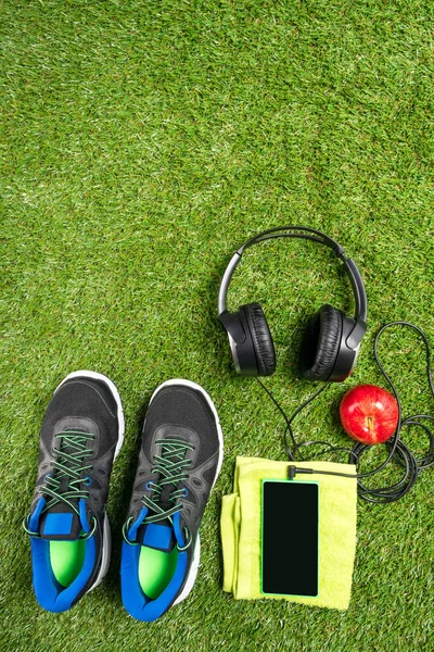 müzik ve yeşil çim bir arka plan üzerinde kırmızı elma ile spor ayakkabı