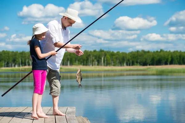 Papá y su hija atrapados un pez en un cebo en el lago —  Fotos de Stock