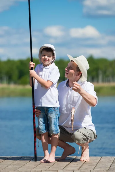 Papá y su hijo atrapados peces en un cebo en el lago —  Fotos de Stock