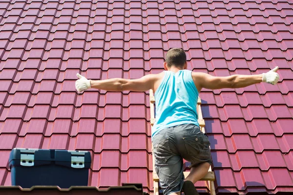 De man verspreid zijn handen voor de inscriptie op de achtergrond van het dak Stockfoto