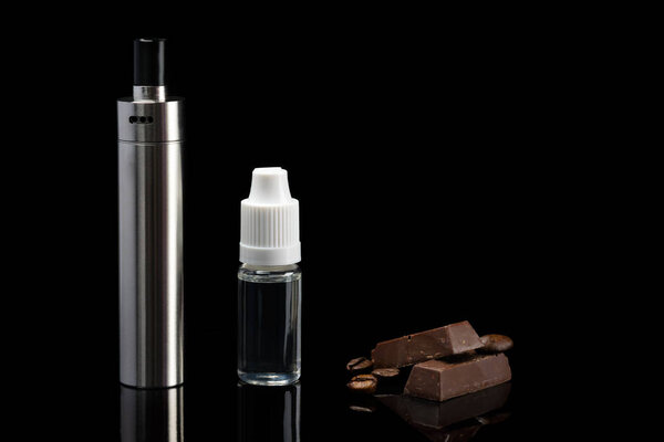 Concept of electronic cigarette and aroma of chocolate with a coffee, on a black background with reflection