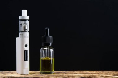 Onun dolumu için sıvı yanındaki masada beyaz bir elektronik sigara olduğunu ve yazıt için bir yer