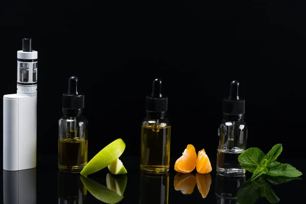 Liquidi di frutta per una sigaretta elettronica, insieme a frutta su sfondo nero — Foto Stock