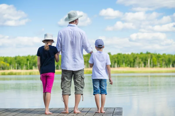 Vader zijn dochter en zoon naar de pier gebracht om te kijken naar het mooie meer — Stockfoto
