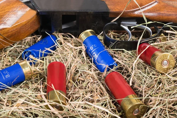 The hunting rifle and cartridges lie on the background of hay — Stock Photo, Image