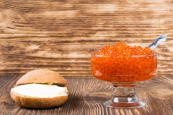 Alter hölzerner Hintergrund mit einem Teller roten Kaviars, Platz für Beschriftung — Stockfoto