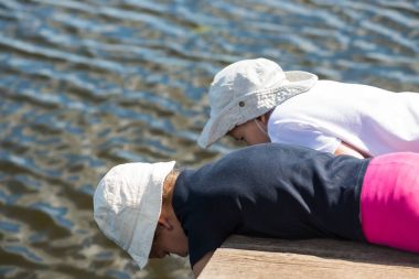 İskelede su ile oynarken kardeş