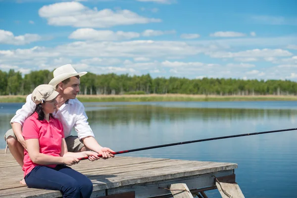 Hombre ayuda a una mujer a pescar en la naturaleza —  Fotos de Stock