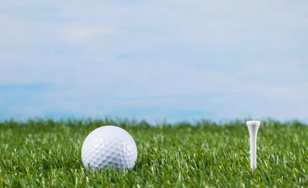 Pelota de golf en un césped verde contra el cielo —  Fotos de Stock