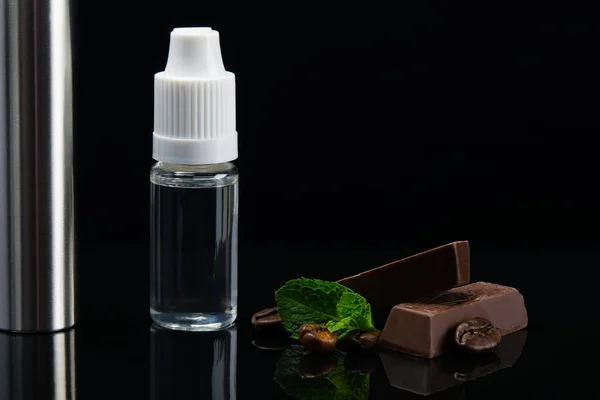 Sabor de chocolate com aroma de hortelã em uma garrafa na forma de líquido em um fundo preto — Fotografia de Stock
