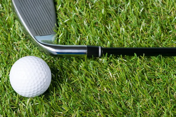Putter e conceito de bola de golfe na grama verde — Fotografia de Stock