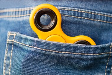 Spinner oyuncak sinir için mavi kot pantolon cebinde yatıyor