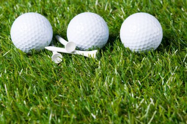 Üç beyaz topu arka plan olarak golf oynamak için bir çim üzerinde yalan