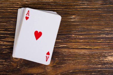 Bir deste kart koyu ahşap bir masa üzerinde bir as ile