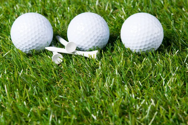 Drei weiße Bälle liegen auf einer Wiese zum Golfspielen als Hintergrund — Stockfoto