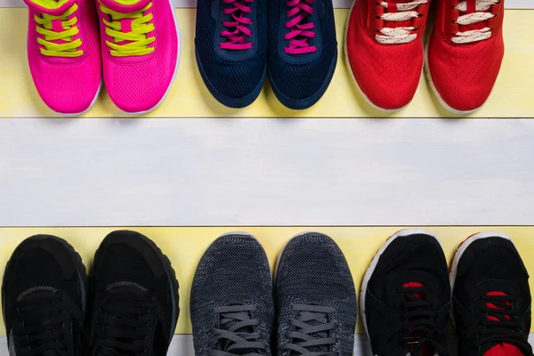 Sets of sports shoes on the wooden floor, as a background for the inscription