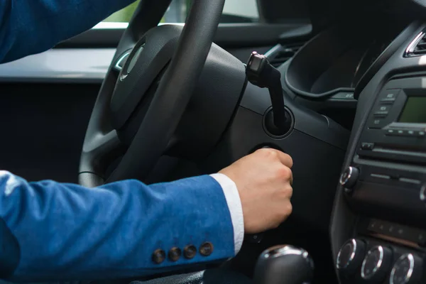 Primer plano de la mano en el coche cerca del volante, arranque de la llave del motor — Foto de Stock