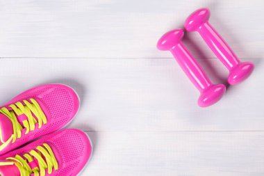 Erkek spor, pembe dumbbells ile ışık ahşap zemin üzerinde oynamak için ayarla