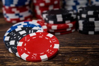 Poker fişleri ahşap bir masa üzerinde dağınık bir arka plan ile