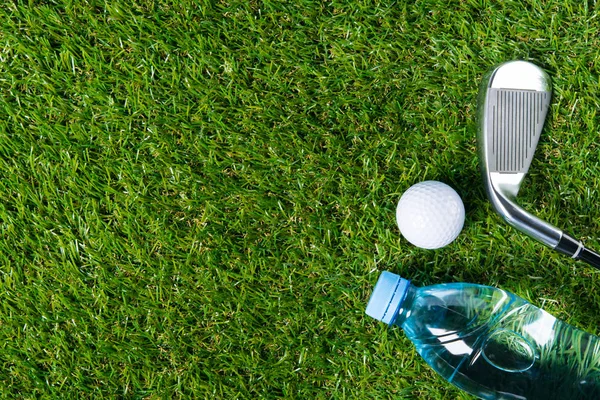 Auf einer grünen Rasenfläche zum Golfspielen und einer Flasche Wasser gibt es einen Platz für eine Inschrift — Stockfoto