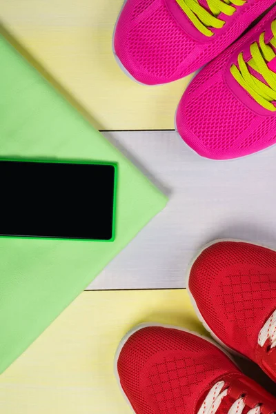 조깅, 신발 및 녹색 수건에 음악 전화의 2 개 쌍에 대 한 밝은 배경 — 스톡 사진