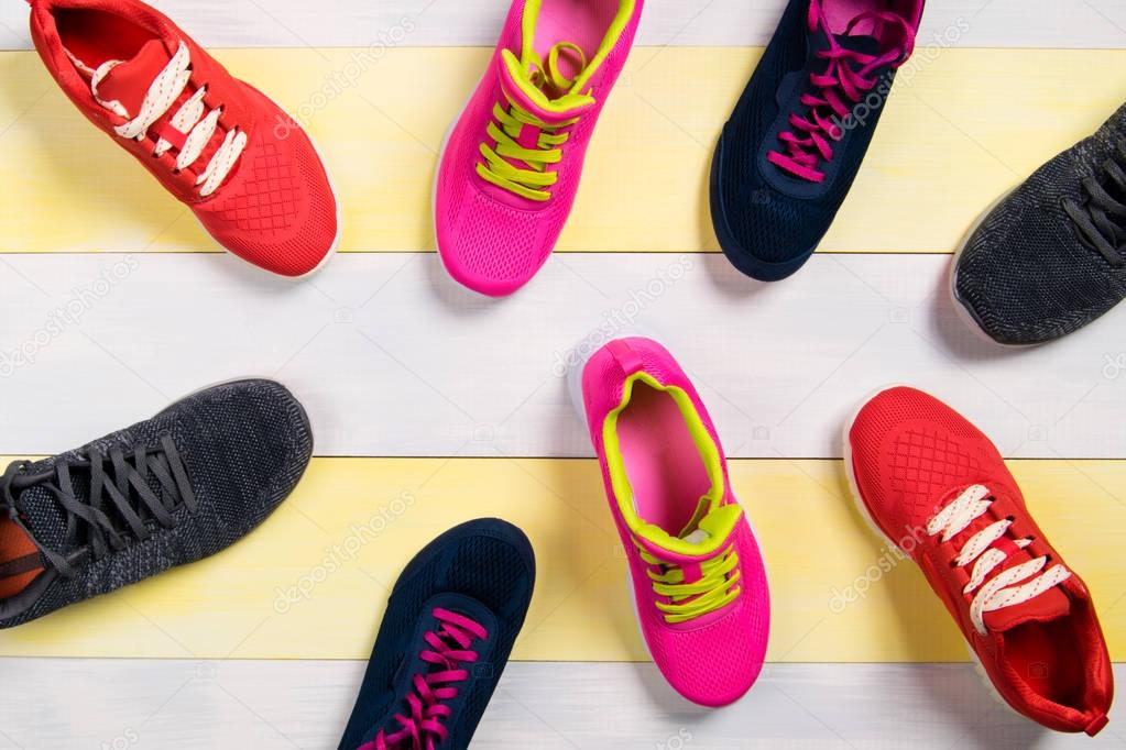 Scattered sports shoes on a multi-colored floor, background