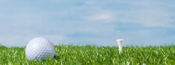 Balle blanche se trouve sur une pelouse pour jouer au golf, sur un fond bleu ciel — Photo