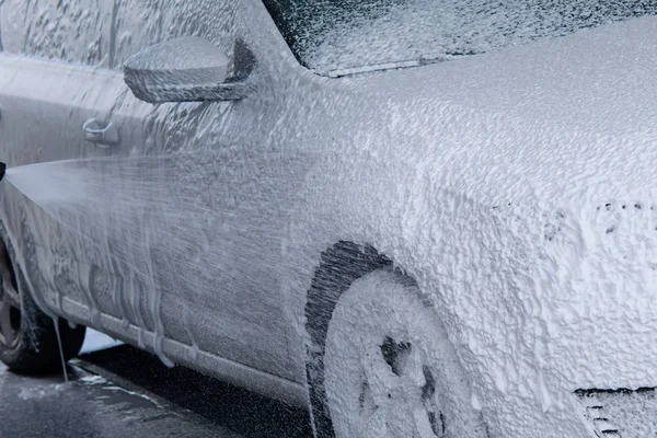 Contactless foam for washing the car flows down the body of the car — Stock Photo, Image