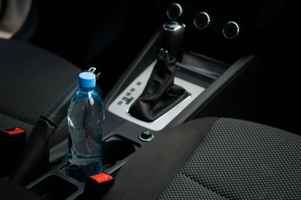 В машине в держателе для чашек есть бутылка воды. — стоковое фото