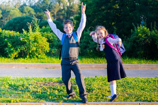 Девочка и мальчик после школы играют и улыбаются — стоковое фото