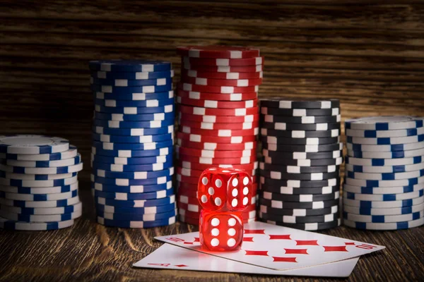 Dos cubos de póquer rojo se encuentran en las cartas en el fondo de las fichas de póquer —  Fotos de Stock