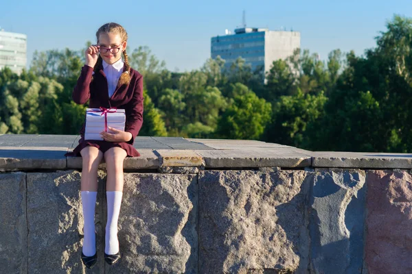 Školačka sedí a drží knihy ze školy — Stock fotografie