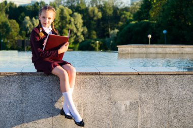 Temiz havada bir parkta bir kız okul sınıfları sonra oturur