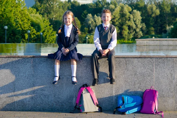 Pojke och flicka sitter tillsammans i parken efter skolan — Stockfoto