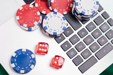 Bir dizüstü bilgisayar ve telefon online poker oynuyor