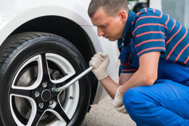 tekerlek ile bir anahtar onun elinde bir usta tarafından değiştirilmesi