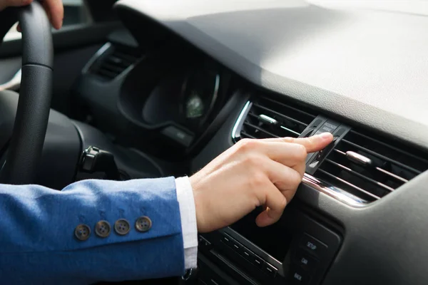 Рука водителя автомобиля открывает воздухозаборник на автомобильной панели — стоковое фото