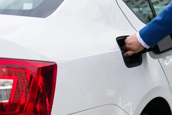Мужская рука открывает крышку цистерны бензином из машины — стоковое фото
