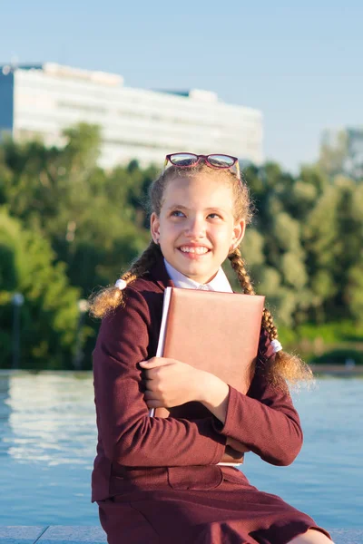 Fille en uniforme scolaire détient un dossier pour l'école — Photo