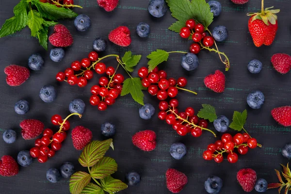 Siyah arka plan kırmızı kuş üzümü Karpuzu yaban mersini ile karışık yüzeyi ile
