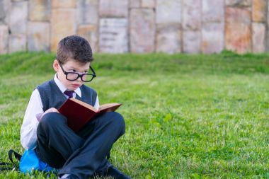 Gözlük, çocukta bir kitapta park açık havada okuma çim oturan öğrenci