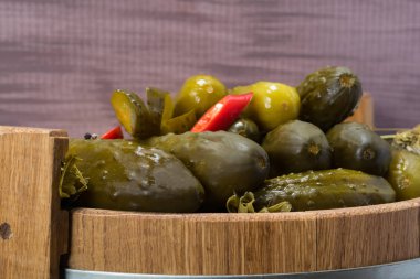 bir varilin içine kırmızı biber ile tuzlu salatalık yalan