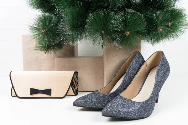 Λαμπερό ζευγάρι παπούτσια και μια μικρή τσάντα, στέκονται κάτω από ένα χριστουγεννιάτικο δέντρο — Φωτογραφία Αρχείου