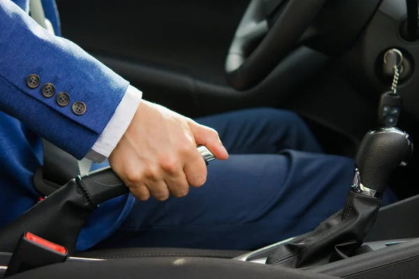 O homem define o carro para o freio de mão, levantando-o para o topo — Fotografia de Stock