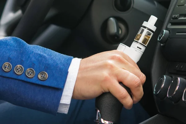 A mão do motorista muda a velocidade do carro, manter o cigarro eletrônico, close-up — Fotografia de Stock