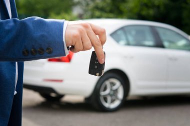 Araba anahtarında beyaz otomatik arka plan üzerinde eller